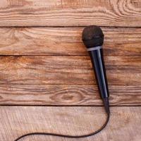 Microphone on wooden background. Toned image. photo