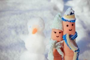 Finger art of a Happy couple on the background of snow. A man and a woman hug. photo