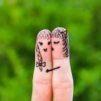Finger art of two women. woman is kissing his girlfriend on the cheek. photo