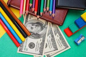 Pens, colored pencils, plasticine, book, hundred dollar bills photo