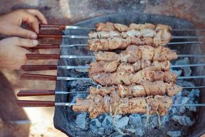 Raw meat is fried at the stake. Male fry the kebabs on grill photo