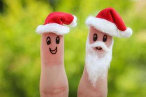 Face painted on the fingers. Santa Claus gives gifts photo