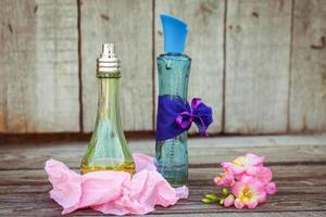 Blue and green perfume bottles near flowers fresia. photo