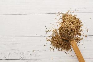 cumin seeds on spoon on table with copy space photo