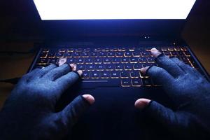 hacker hand stealing data from laptop top down photo