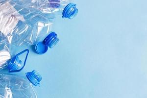 a lot of plastic empty rumpled used bottles on a blue background. waste and pollution concept photo