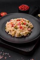 Delicious boiled rice with vegetables peppers, carrots, peas and asparagus beans photo