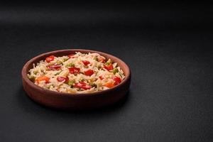 Delicious boiled rice with vegetables peppers, carrots, peas and asparagus beans photo