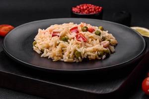 Delicious boiled rice with vegetables peppers, carrots, peas and asparagus beans photo
