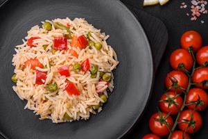 Delicious boiled rice with vegetables peppers, carrots, peas and asparagus beans photo