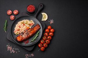 Delicious red salmon fish grilled with sauce and sesame seeds with rice and vegetables photo
