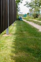 a man mows a lawn with a lawn mower photo