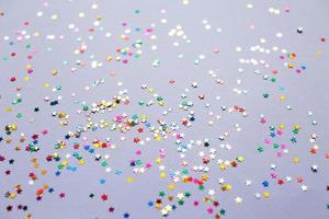 multicolor sparkles on a purple background. Festive backdrop for your projects. photo