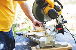 a man is cutting boards with a saw outdoor photo