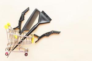 various hairdressing tools with shopping cart on a beige background. beauty salon concept photo