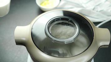 chef is gieten melk in menging deeg machine, huis bakkerij voorbereiding werkwijze concept video