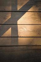 Wooden background of an old board in the evening light with shadows. photo