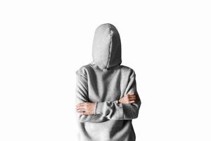 Teenager in a hoodie with a hood on a white background. The arms are folded over the chest. photo