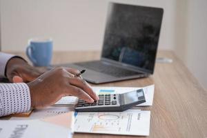 africano negro empresario sentado haciendo un financiero reporte y estudiando anual lucro análisis un contador comprobación el financiero estado de el empresa es en el oficina. foto