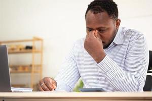 An American businessman with black skin in Africa feels uncomfortable at work and wrist pain is caused by the accumulated stress from failing to complete the job. and the body rests a little. photo