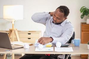 An American businessman with black skin in Africa feels uncomfortable at work and wrist pain is caused by the accumulated stress from failing to complete the job. and the body rests a little. photo