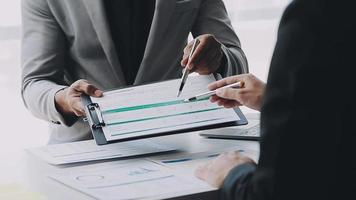 Financial analysts analyze business financial reports on a digital tablet planning investment project during a discussion at a meeting of corporate showing the results of their successful teamwork. video