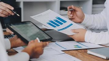Financial analysts analyze business financial reports on a digital tablet planning investment project during a discussion at a meeting of corporate showing the results of their successful teamwork. video