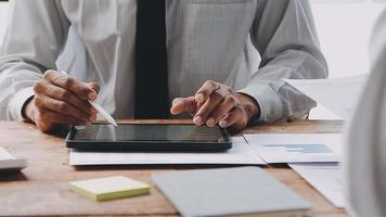 Financial analysts analyze business financial reports on a digital tablet planning investment project during a discussion at a meeting of corporate showing the results of their successful teamwork. video