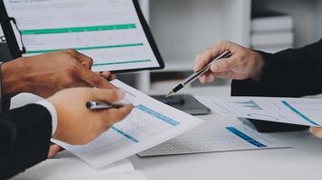 Financial analysts analyze business financial reports on a digital tablet planning investment project during a discussion at a meeting of corporate showing the results of their successful teamwork. video