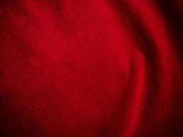 textura de tela de terciopelo rojo oscuro utilizada como fondo. fondo de tela rojo oscuro vacío de material textil suave y liso. hay espacio para el texto. foto