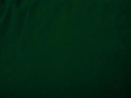 textura de tela de terciopelo verde oscuro utilizada como fondo. fondo de tela verde vacío de material textil suave y liso. hay espacio para el texto.. foto