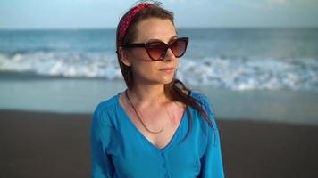 Portrait of a woman in a beautiful blue dress on a black volcanic beach video