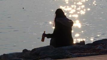 Silhouette von einsam Frau Trinken Bier allein auf Sonnenschein Strand video