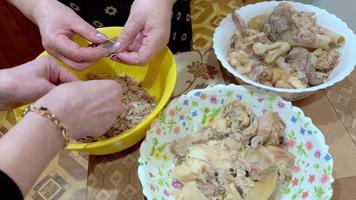 mulheres mãos estão Ordenação e Ordenação fervido carne para dentro pratos quando preparando uma carne prato. video