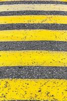 Old road markings for pedestrians with yellow stripes. photo