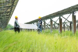 Engineering and technician unloading repaired solar panels to be installed on the rows of solar cells lined up on hundreds of acres of grass photo