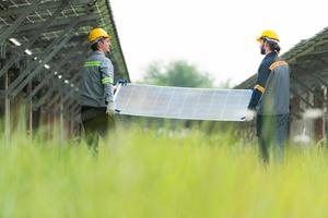 Engineering and technician unloading repaired solar panels to be installed on the rows of solar cells lined up on hundreds of acres of grass photo