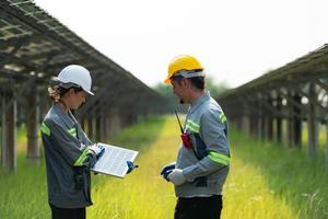 At hundreds of acres of grass with solar panels A team of electric power engineers is testing a prototype of a small solar panel installed on this field. photo