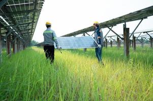 Engineering and technician unloading repaired solar panels to be installed on the rows of solar cells lined up on hundreds of acres of grass photo
