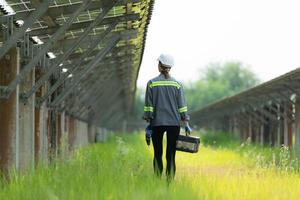 Technicians are walking to inspect solar panels according to the daily inspection schedule. To keep repairing and checking the efficiency of solar cells photo