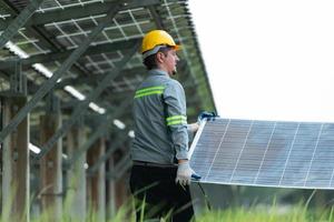 Engineering and technician unloading repaired solar panels to be installed on the rows of solar cells lined up on hundreds of acres of grass photo