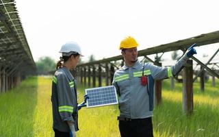 At hundreds of acres of grass with solar panels A team of electric power engineers is testing a prototype of a small solar panel installed on this field. photo