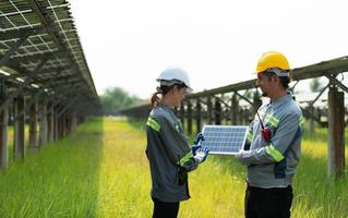 At hundreds of acres of grass with solar panels A team of electric power engineers is testing a prototype of a small solar panel installed on this field. photo