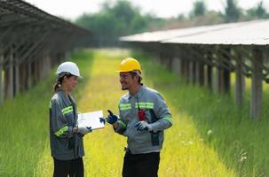 At hundreds of acres of grass with solar panels A team of electric power engineers is testing a prototype of a small solar panel installed on this field. photo