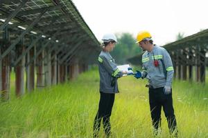 At hundreds of acres of grass with solar panels A team of electric power engineers is testing a prototype of a small solar panel installed on this field. photo