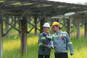 At hundreds of acres of grass with solar panels A team of electric power engineers is testing a prototype of a small solar panel installed on this field. photo