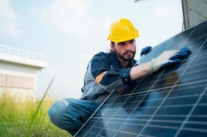 An electrical engineer is inspecting a solar cell that has been used for some time, installed on a field hundred acres of grass. photo