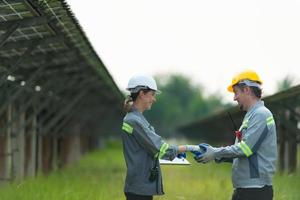 At hundreds of acres of grass with solar panels A team of electric power engineers is testing a prototype of a small solar panel installed on this field. photo