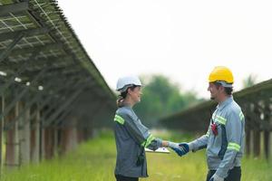 At hundreds of acres of grass with solar panels A team of electric power engineers is testing a prototype of a small solar panel installed on this field. photo