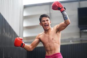 Muay Thai, The martial art of Thailand, Boxer's happiness when he wins by standing on the ropes of the boxing ring and raising his hands and shouting satisfactorily photo